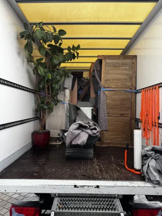 Gesicherte Ladung im Umzugs-LKW mit Möbeln und Zimmerpflanze
