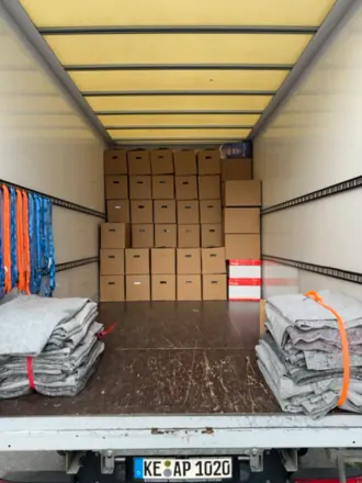 Umzugs-LKW mit gestapelten Umzugskartons und Umzugsdecken