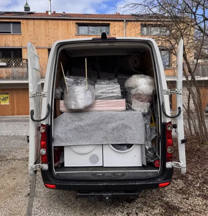 Transporter mit Waschmaschine, Trockner und verpackten Möbeln
