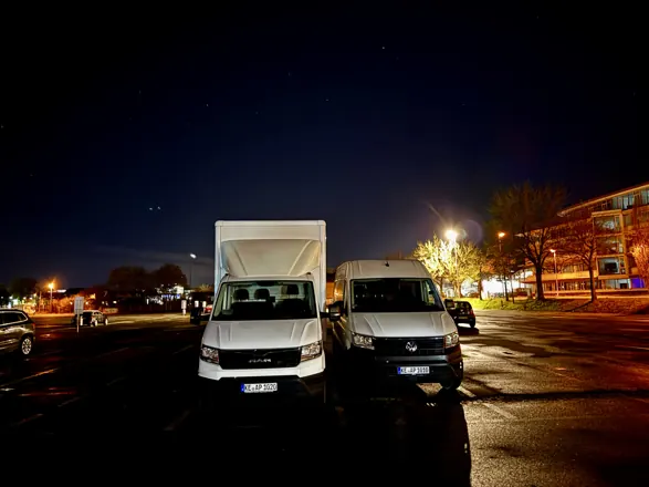 Transporter und LKW bei einem zweitägigen Umzug am Abend