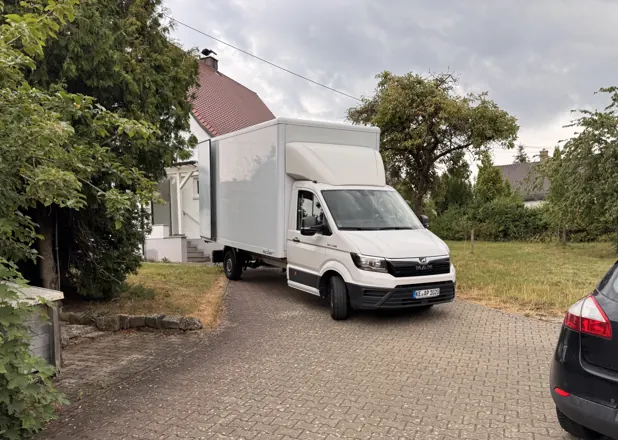 Umzugs-LKW von AP-Umzugsservice in der Einfahrt eines Wohnhauses