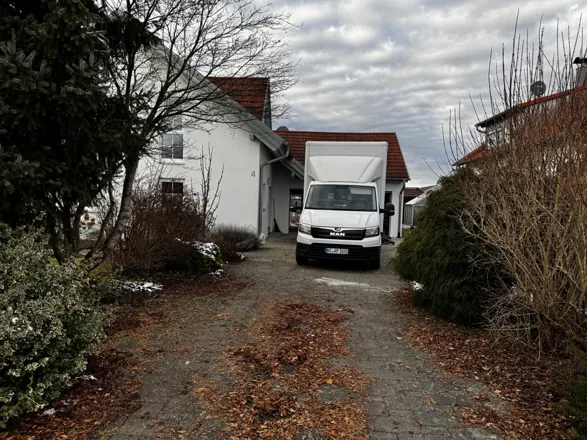 Umzugs-LKW von AP-Umzugsservice vor einem Einfamilienhaus im Winter